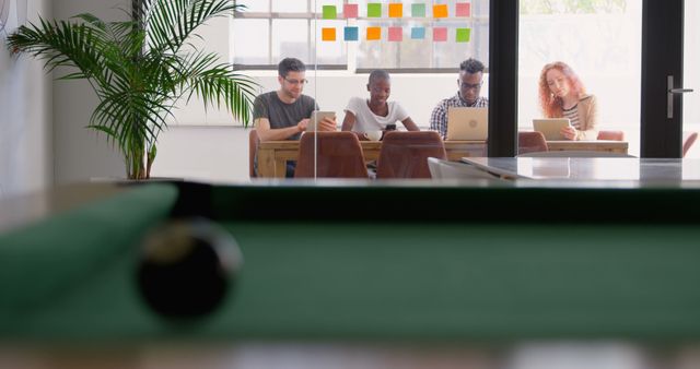 Team Collaborating in Modern Office with Pool Table in Foreground - Download Free Stock Images Pikwizard.com