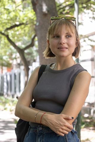 Young woman standing with arms crossed wearing sunglasses on head casual urban summer style