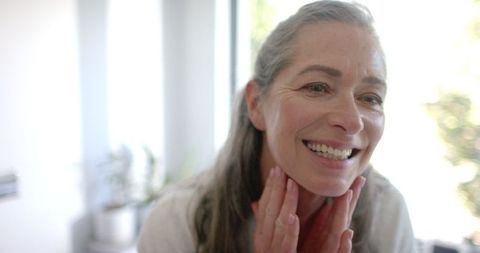 Mature Woman with Grey Hair Smiling and Enjoying Self-Care