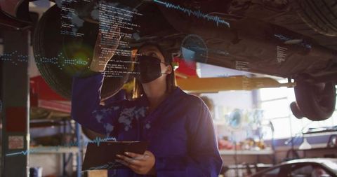 Mechanic inspecting lifted car using tablet with augmented reality diagnostics overlay