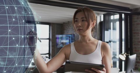 Businesswoman Interacting with Digital Globe Interface in Modern Office