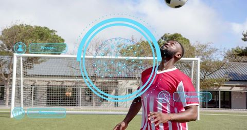 Heading soccer ball under blue augmented reality HUD on outdoor goal line pitch