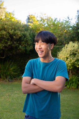Laughing Teenager with Braces Relaxing in Lush Garden