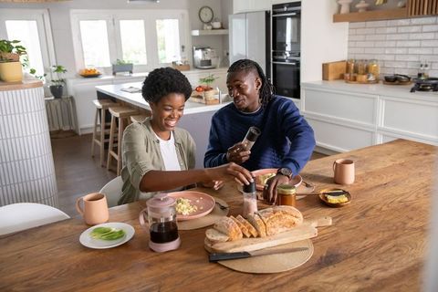 African american couple enjoying breakfast together in modern kitchen