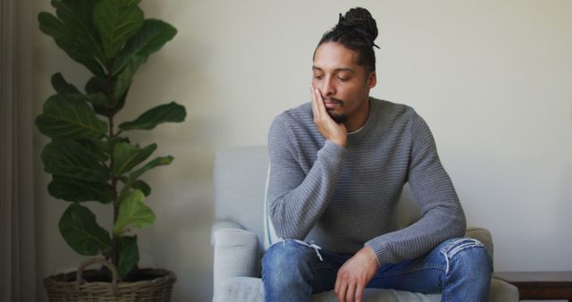 Reflective Biracial Man with Dreadlocks Sitting in Living Room - Download Free Stock Images Pikwizard.com