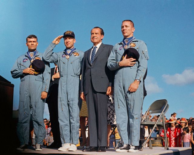 S70-15526 (18 April 1970) --- President Richard M. Nixon and the Apollo 13 crew members pay honor to the United States flag during the post-mission ceremonies at Hickam Air Force Base, Hawaii.  Astronauts James A. Lovell Jr., (United States Navy Captain, salutes the flag) commander; John L. Swigert Jr., command module pilot (right); and Fred W. Haise Jr., lunar module pilot (left), were presented the Presidential Medal of Freedom by the Chief Executive.  The Apollo 13 splashdown occurred at 12:07:44 p.m. (CST), April 17, 1970, about a day and a half prior to the award presentation.