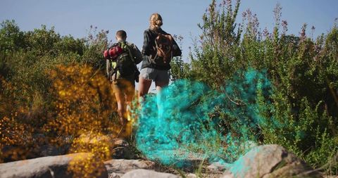 Hikers Exploring Trail With Colorful Smoke in Wilderness