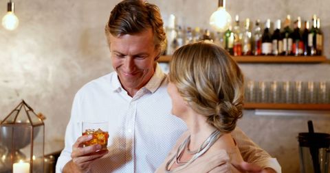 Middle-Aged Couple Enjoying Warm Moment at Cozy Bar - Download Free Stock Images Pikwizard.com
