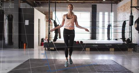 Woman jumping rope in modern urban gym