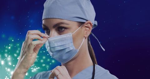 Female Medical Professional Adjusting Face Mask Amid Sparkling Background