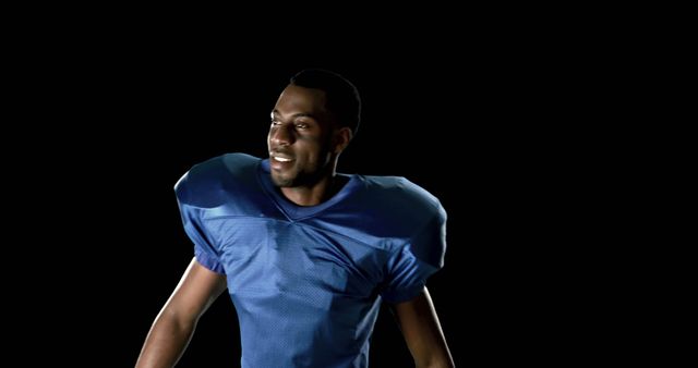 Young male football player smiling wearing blue jersey, representing positivity, confidence, and determination. Perfect for sports advertisements, motivational posters, or athletic promotions.