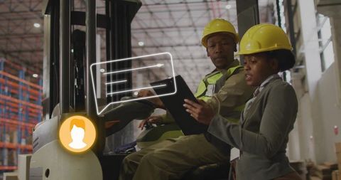 Warehouse Manager Reviewing Logistics on Tablet with Forklift Operator Wearing Hard Hats