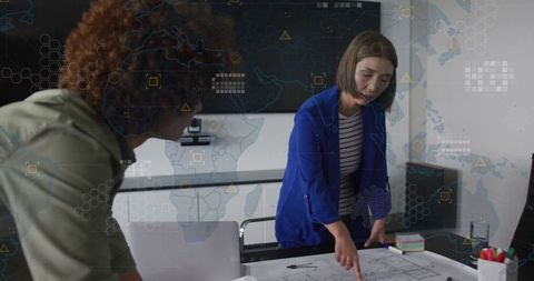 Professionals Collaborating Over Blueprints with Digital Interface