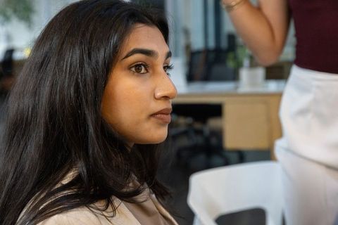 South asian professional woman listening intently in modern office with greenery