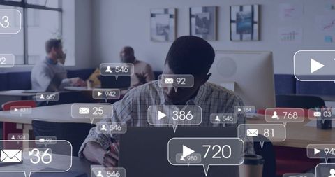 Plaid-shirted man typing on laptop in open office with social badges, analytics, coffee