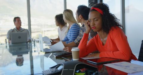 Exhausted businesswoman falling asleep during office meeting
