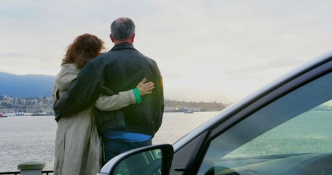 Couple Embracing by Harbor with Scenic View of Sunset