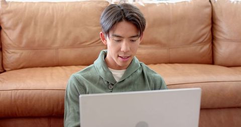 Young Man Working on Laptop in Cozy Minimalist Living Room