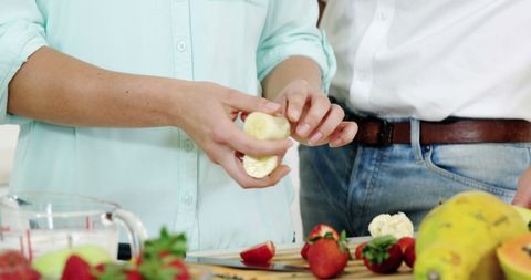 Couple Making Healthy Fruit Smoothie Together in Home Kitchen