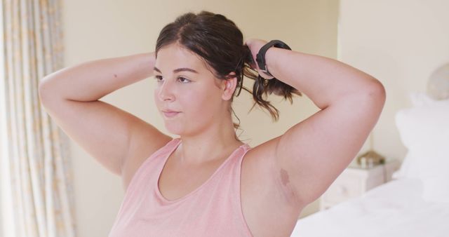 Young Woman Tying Hair Before Fitness Training at Home - Download Free Stock Images Pikwizard.com