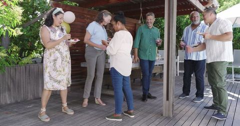 Elderly Friends Celebrating Party Outdoors on Wooden Deck
