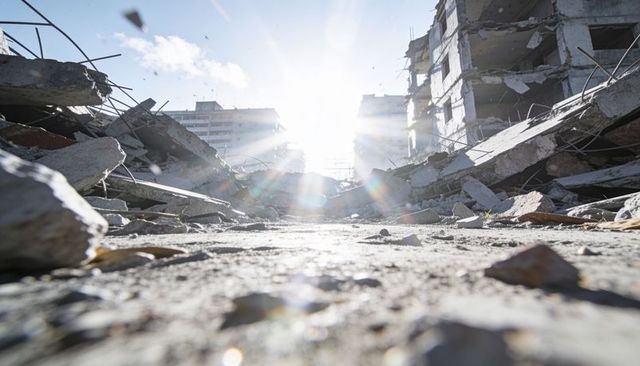 Sunlight bursting through collapsed concrete rubble on urban street with twisted rebar