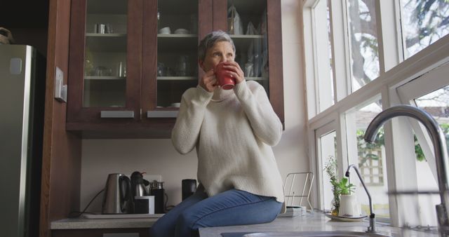 Relaxed Senior Woman Drinking Coffee by Kitchen Window - Download Free Stock Images Pikwizard.com