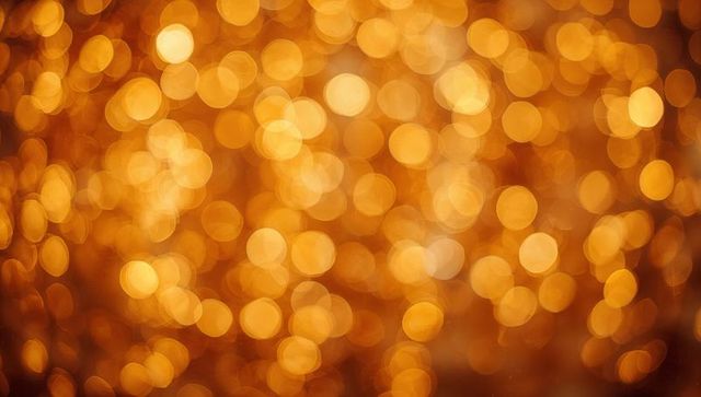 Golden bokeh lights background glowing warm amber circles festive abstract blur texture
