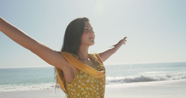 Caucasian woman with long hair is standing on the beach, stretching out his hands and smiling. Summer, free time, chill, vacation, happy time.