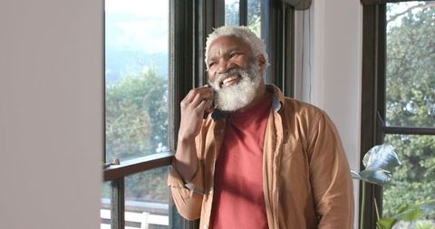 Senior Man Relaxing at Home While Talking on Smartphone