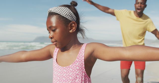 Father and daughter having fun at the beach on a sunny day, engaging in playful activities. Great for topics related to family bonding, summer vacations, outdoor fun, and childhood memories.