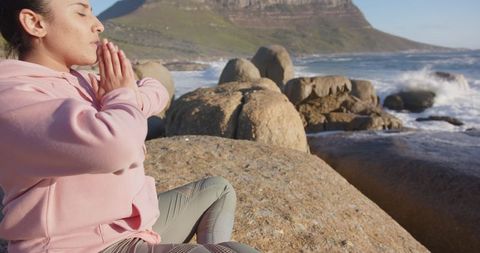 Woman Meditating in Nature on Rocky Seaside