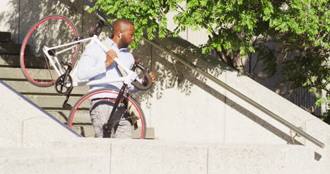 Active Man Carrying Bicycle Down Urban Steps