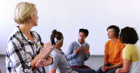 Group Therapy Session with Diverse Adults and Female Facilitator