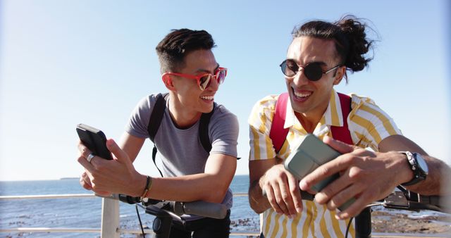 Two Happy Friends with Smartphones on Scooter Ride by Seaside - Download Free Stock Images Pikwizard.com