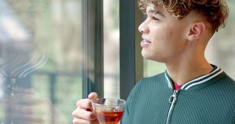 Young Man Contemplating Life While Drinking Tea at Home