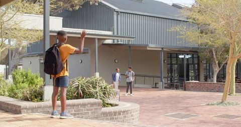Friendly Wave at School Plaza with Young Students Enhancing Community Spirit