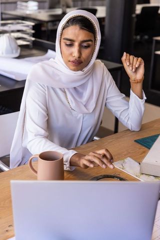 Architectural designer working on laptop in modern creative office