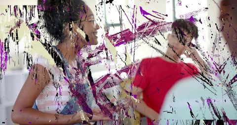 Teens collaborating in bright studio with paint-smeared window and creative discussion