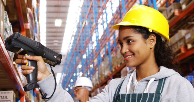 Smiling biracial woman using scanner working in warehouse with copy space. Shipping, delivery, business and work concept, unaltered.