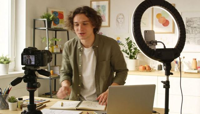 Recording artist demonstrating sketching techniques in home studio with dslr and ring light