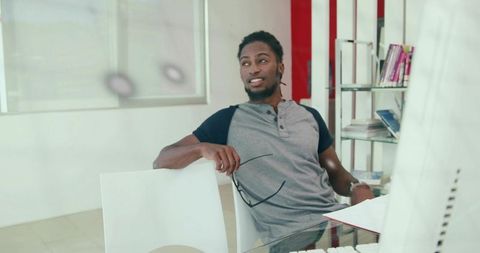 Confident Businessman Relaxing at Office Desk with Glasses in Hand