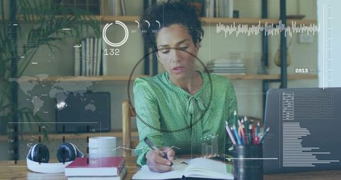 Mature woman working in sunlit home office with futuristic hud overlays writing notes
