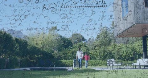 Man and boy walking on lawn holding hands pulling wheeled suitcase with chemistry overlay
