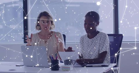 Diverse Businesswomen Collaborating in Tech-Inspired Office