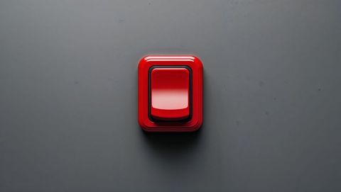 Glossy red button on matte grey surface, red alert button concept