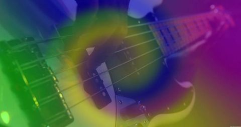 Electric bass guitarist performing under colorful stage lights