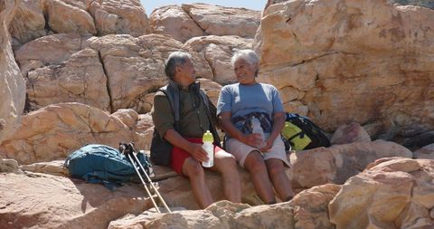 Senior Couple Enjoying Hiking Break Amidst Rocks