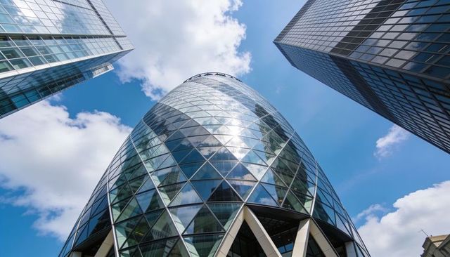 Diamond-grid glass tower reflecting blue sky with triangular supports and skyscrapers