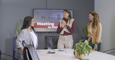 Diverse professional women leading collaborative meeting in modern boardroom